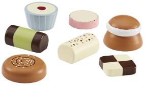 Sju sorters kakor gjorda i trä ligger framlagda. Ser verklighetstroget ut.