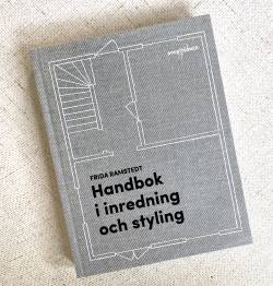 Stilfull grå bok med titel i svart och konturerna av en planskiss i vitt runtom.