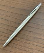 En Parker Jotter-penna i stål som ligger på ett brunt träbord.