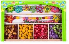 Kartong som visar två tomma pärlplattor föreställande en häst och en hund. Bredvid syns färgglada pärlor lagda i dessa mönster som bildar en brun hund och en vit häst med rosa man och svans.